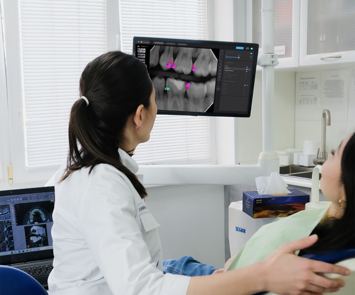 Dentist showing AI-enhanced dental X-ray on screen to a patient in a modern clinic