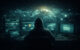 Hooded figure at computer representing global cybercrime networks
