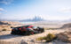 High-performance hypercar in desert landscape with futuristic city skyline in background