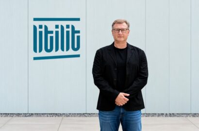 Nikolajus Gavrilinas, co-founder and CEO of LITILIT, standing beside the company's logo